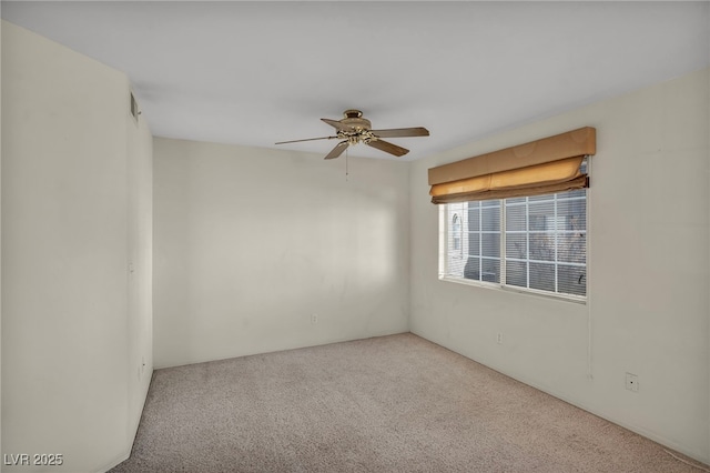 carpeted spare room featuring a ceiling fan and visible vents