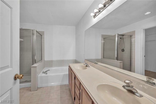 full bathroom with double vanity, a shower stall, a walk in closet, and a sink