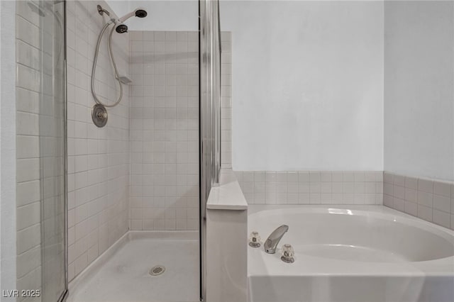 bathroom with a stall shower and a garden tub