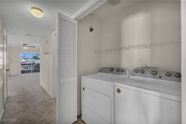 clothes washing area with a ceiling fan, laundry area, light colored carpet, and washing machine and clothes dryer