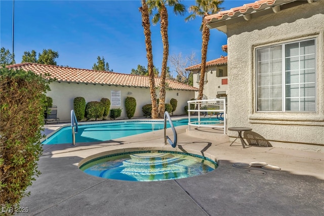 community pool with central AC, a patio area, and a hot tub