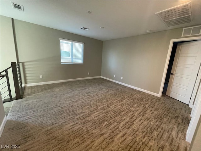 spare room with visible vents, dark wood finished floors, and baseboards