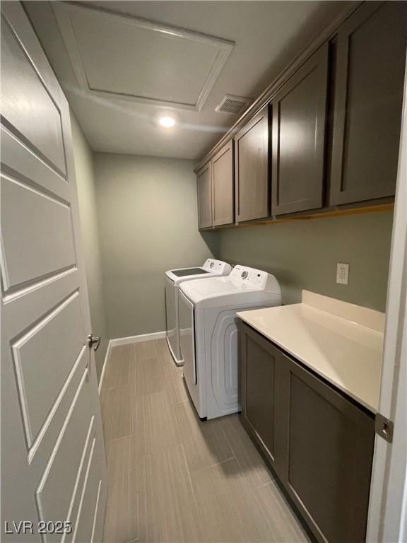 clothes washing area with attic access, cabinet space, independent washer and dryer, and baseboards