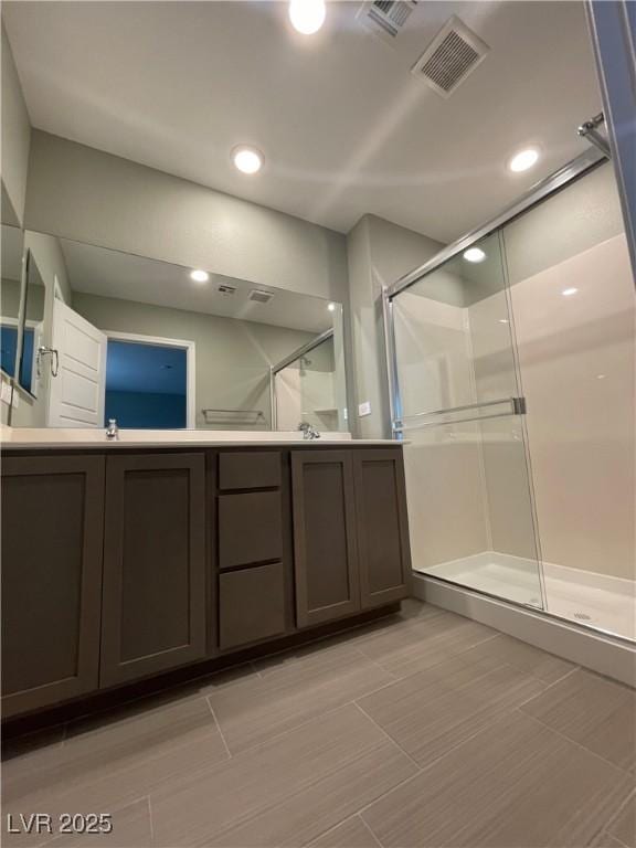 full bathroom featuring vanity, visible vents, and a shower stall