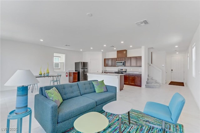 living area with stairs, visible vents, and recessed lighting