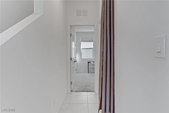 hall featuring light tile patterned floors and visible vents