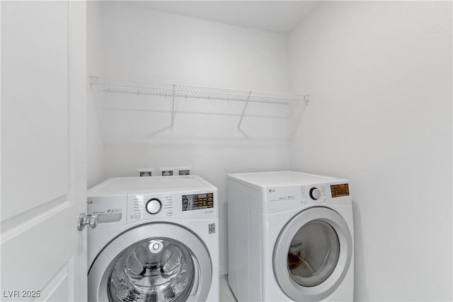 clothes washing area featuring laundry area and washer and clothes dryer