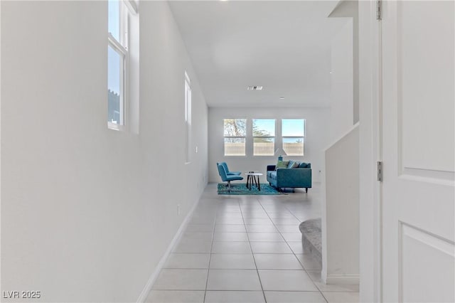 hallway featuring baseboards and light tile patterned flooring