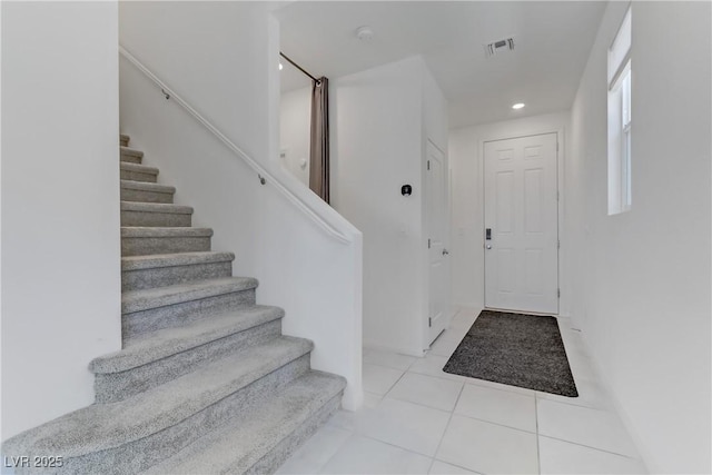 tiled entryway with stairway, visible vents, and recessed lighting