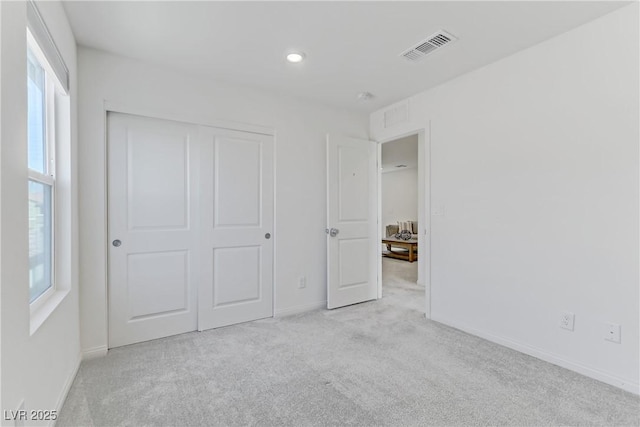 unfurnished bedroom with a closet, visible vents, baseboards, and carpet flooring