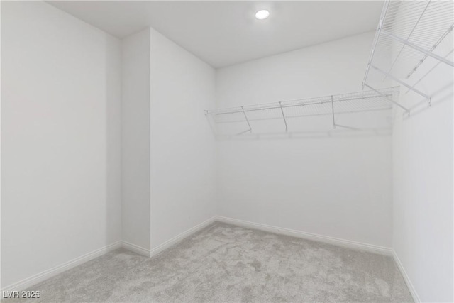 walk in closet featuring light colored carpet