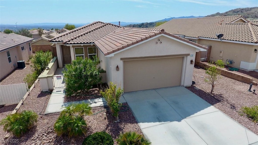view of front of home with a garage, fence, concrete driveway, a tiled roof, and stucco siding