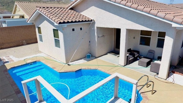 view of swimming pool with a patio and fence