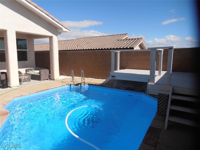 view of swimming pool featuring outdoor lounge area and fence