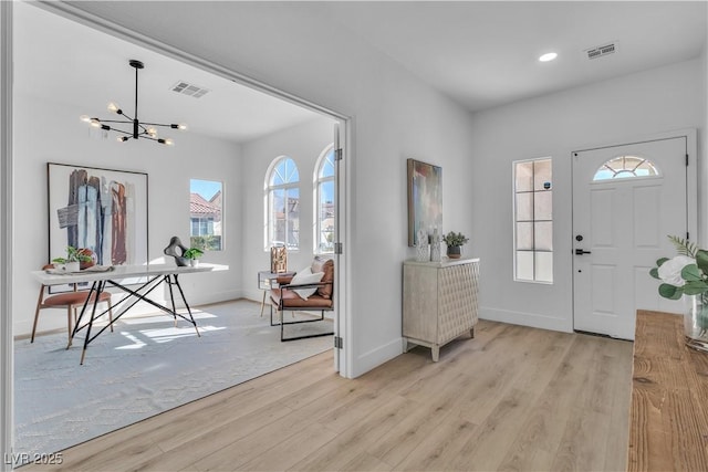 entryway with a wealth of natural light, visible vents, and light wood-style floors