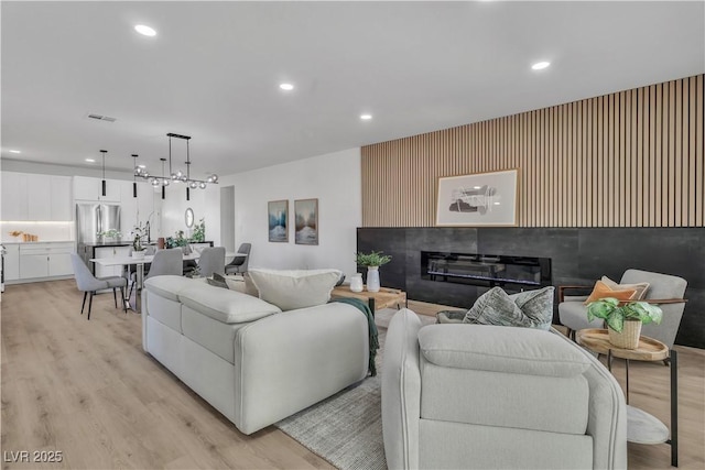 living room featuring recessed lighting, visible vents, and light wood-style floors