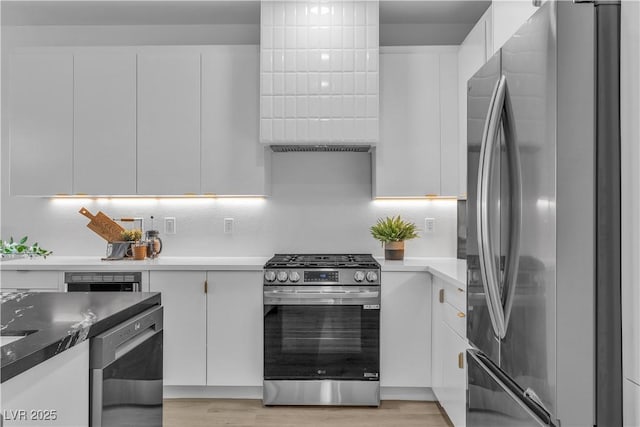 kitchen featuring stainless steel appliances, white cabinetry, light wood finished floors, and modern cabinets