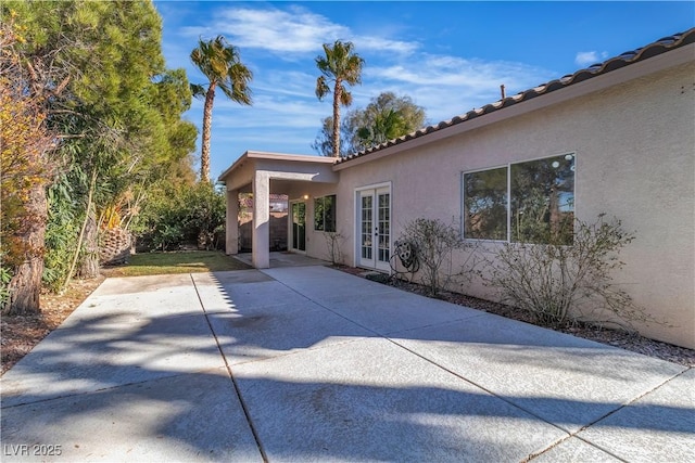 view of home's exterior with a patio, french doors, and stucco siding