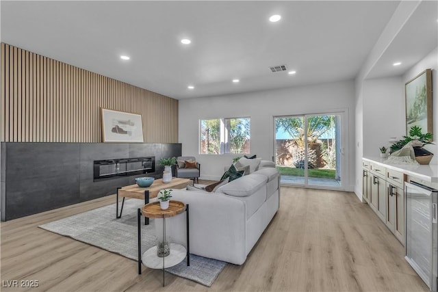 living area with light wood-style floors, wine cooler, visible vents, and recessed lighting