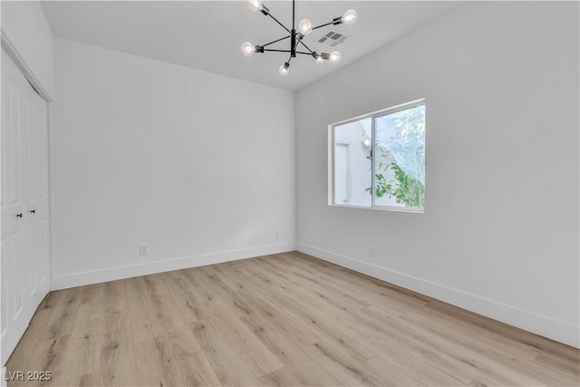 unfurnished room featuring baseboards, light wood-style floors, visible vents, and an inviting chandelier