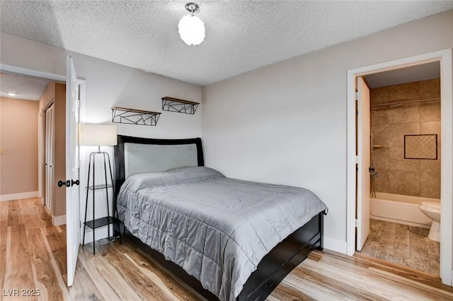 bedroom with a textured ceiling, baseboards, and wood finished floors