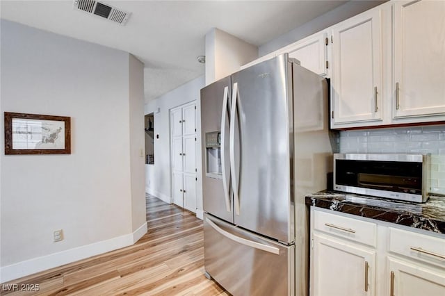 kitchen featuring visible vents, decorative backsplash, appliances with stainless steel finishes, white cabinetry, and light wood-type flooring