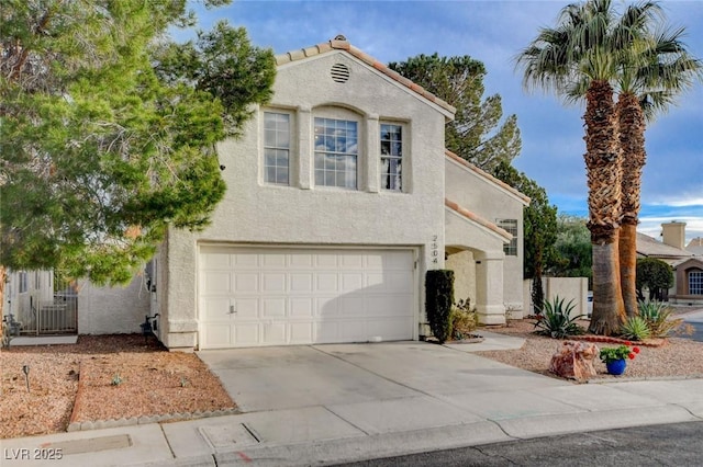 mediterranean / spanish home with a garage, driveway, fence, and stucco siding