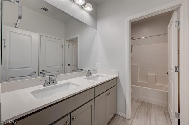 full bathroom featuring visible vents, a sink, bathing tub / shower combination, and double vanity