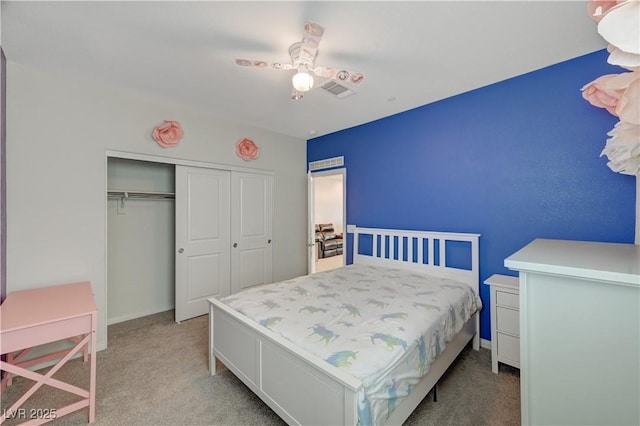 bedroom with baseboards, a ceiling fan, a closet, and light colored carpet