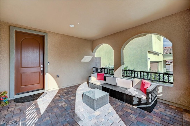 property entrance featuring outdoor lounge area and stucco siding