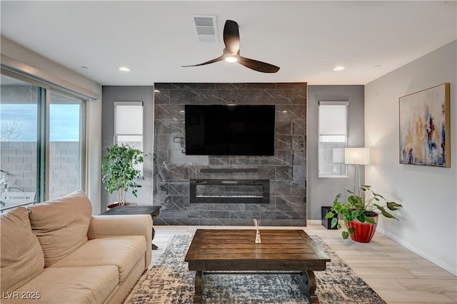 living area featuring visible vents, baseboards, ceiling fan, a fireplace, and recessed lighting