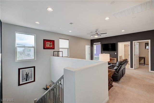 corridor featuring recessed lighting, light colored carpet, visible vents, baseboards, and an upstairs landing