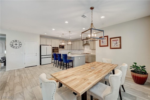 dining space with a chandelier, recessed lighting, visible vents, and baseboards