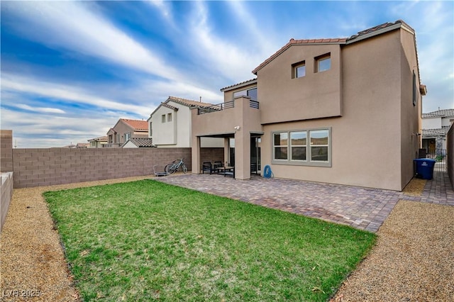 rear view of property featuring a patio area, a fenced backyard, and stucco siding