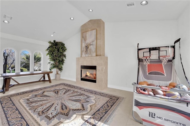 interior space featuring lofted ceiling, a fireplace, visible vents, and recessed lighting