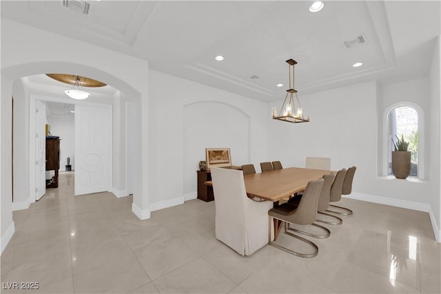 dining space featuring arched walkways, a raised ceiling, visible vents, and recessed lighting