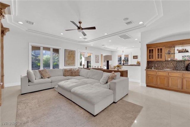 living area featuring baseboards, indoor wet bar, visible vents, and recessed lighting