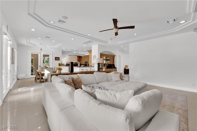 living room with light tile patterned floors, a raised ceiling, and visible vents