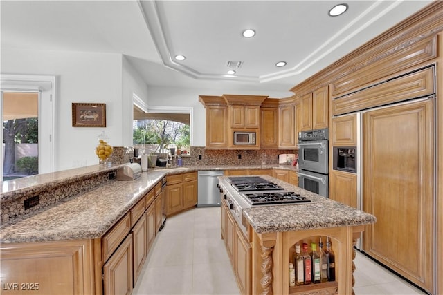 kitchen featuring visible vents, built in appliances, light stone countertops, a tray ceiling, and recessed lighting