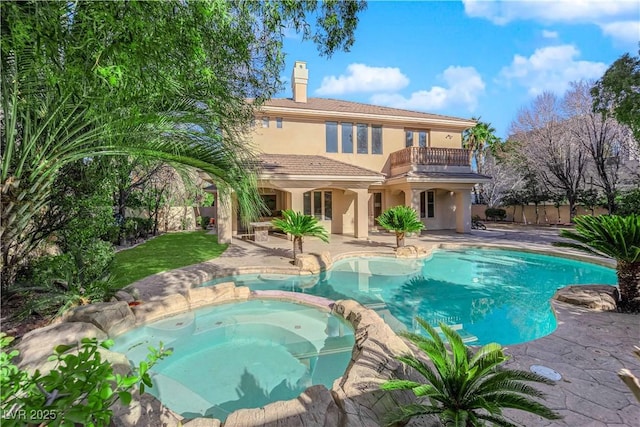 view of pool featuring a pool with connected hot tub, a patio area, and fence