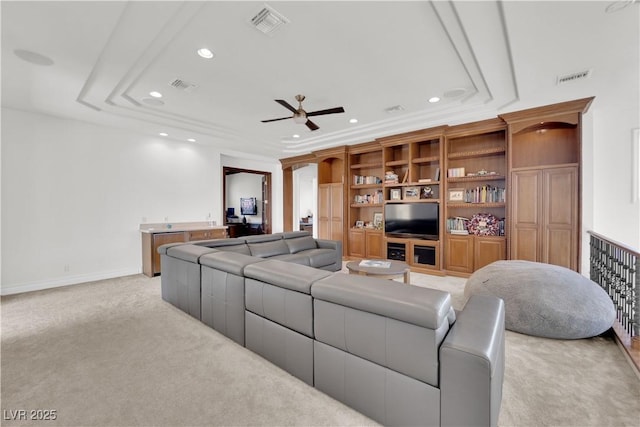 living room with light carpet, visible vents, a raised ceiling, and recessed lighting