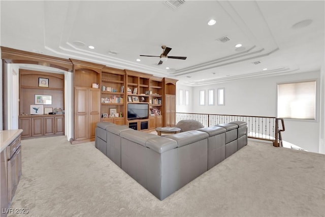 living area with recessed lighting, visible vents, a tray ceiling, and light colored carpet