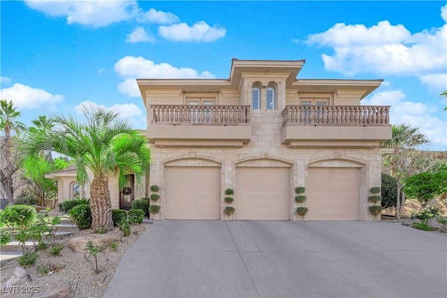 mediterranean / spanish-style home with a balcony, stone siding, an attached garage, and concrete driveway