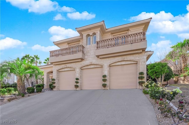 mediterranean / spanish-style home with a balcony, stone siding, an attached garage, and concrete driveway