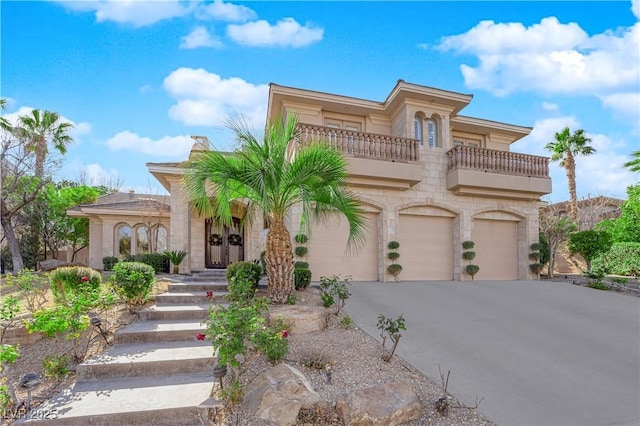 mediterranean / spanish home with driveway, an attached garage, and a balcony