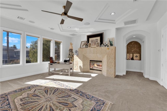 living area with arched walkways, visible vents, a fireplace, and baseboards