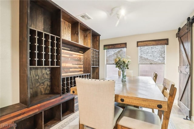 dining space with a barn door and visible vents