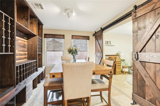 dining area with a barn door and visible vents