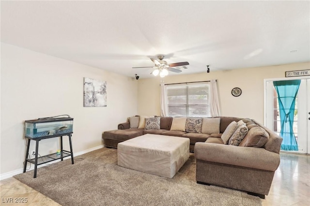 living room with a ceiling fan and baseboards