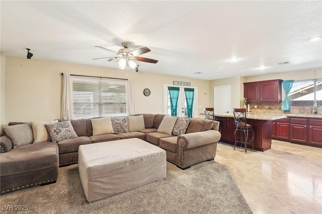 living area featuring ceiling fan, visible vents, and french doors